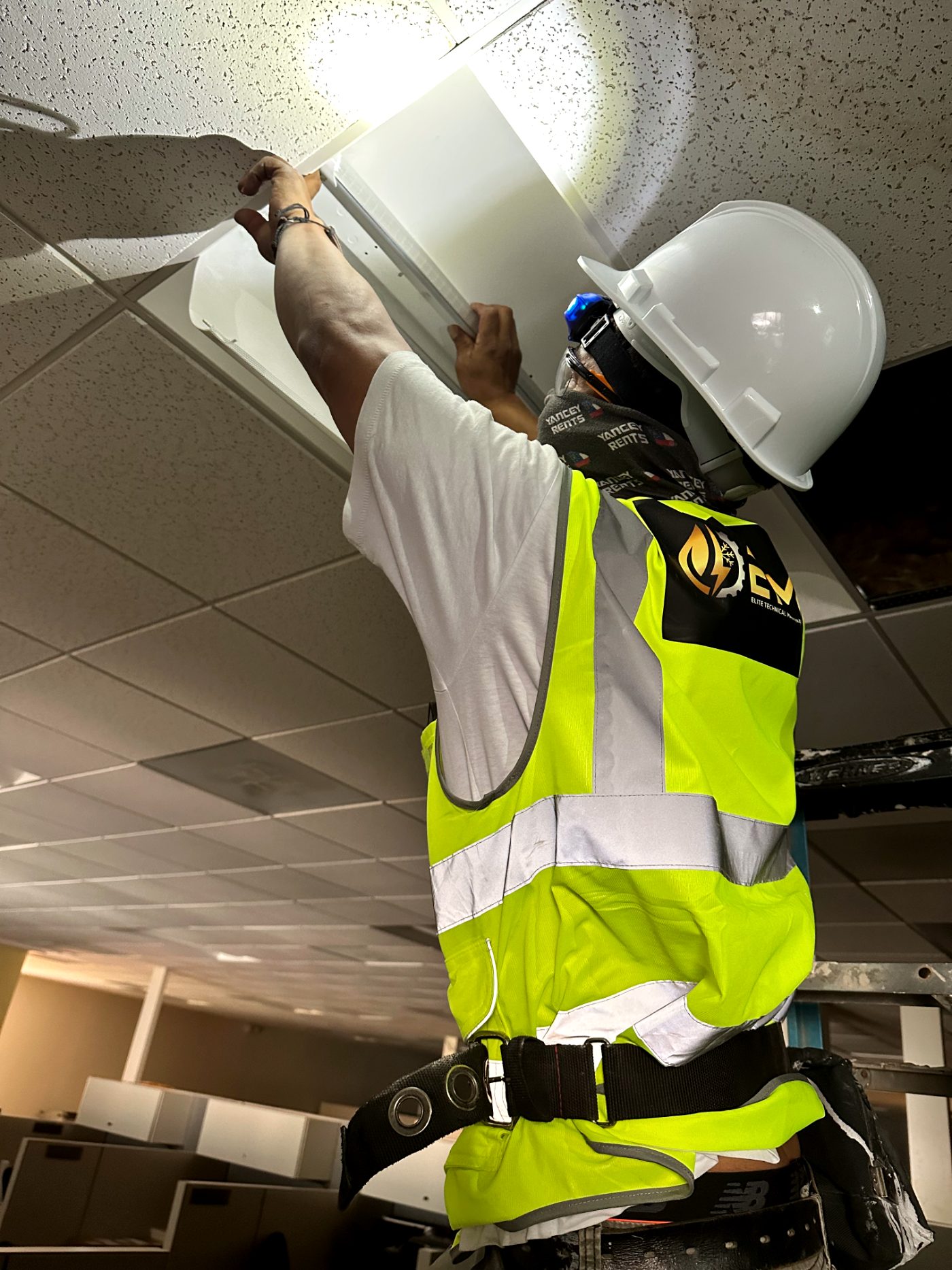 ETM technician servicing ceiling electrical fixtures
